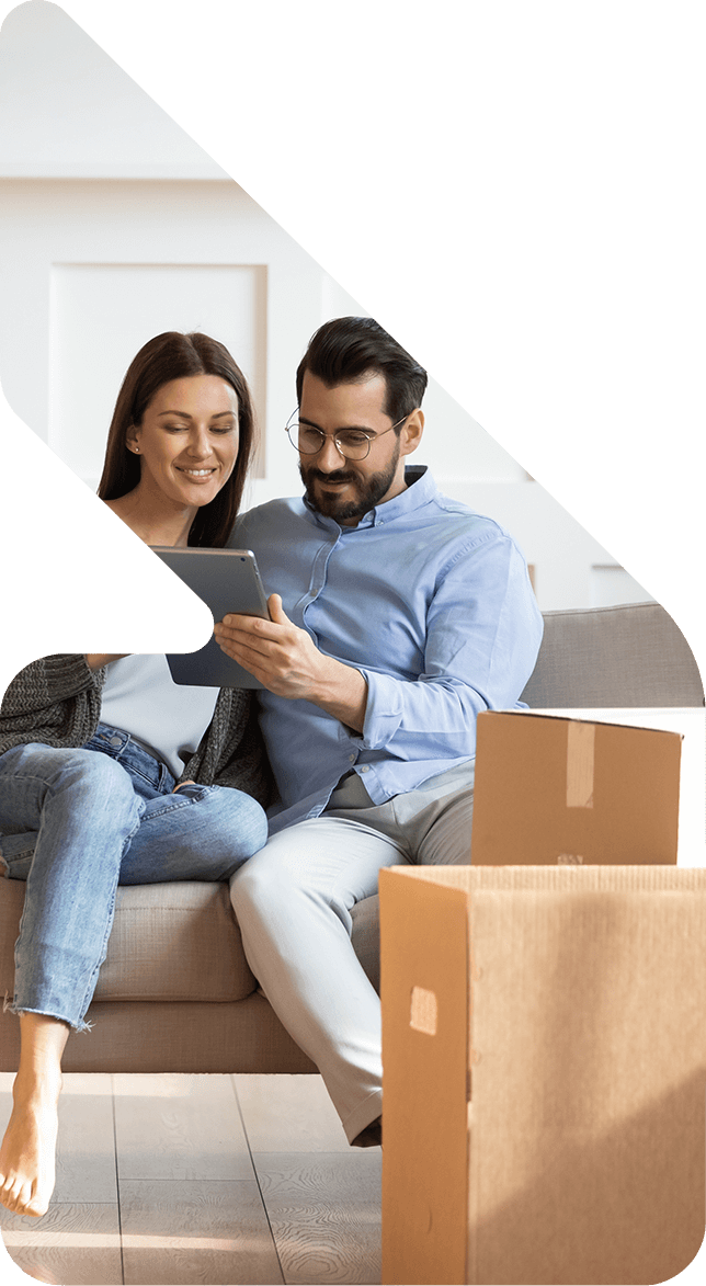 Image showing a couple using a tablet on the couch surrounded by boxes